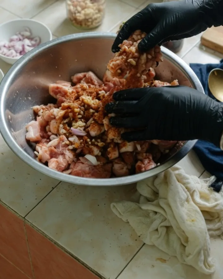 Tay trộn thịt heo với ngũ vị hương, tỏi và hành tím